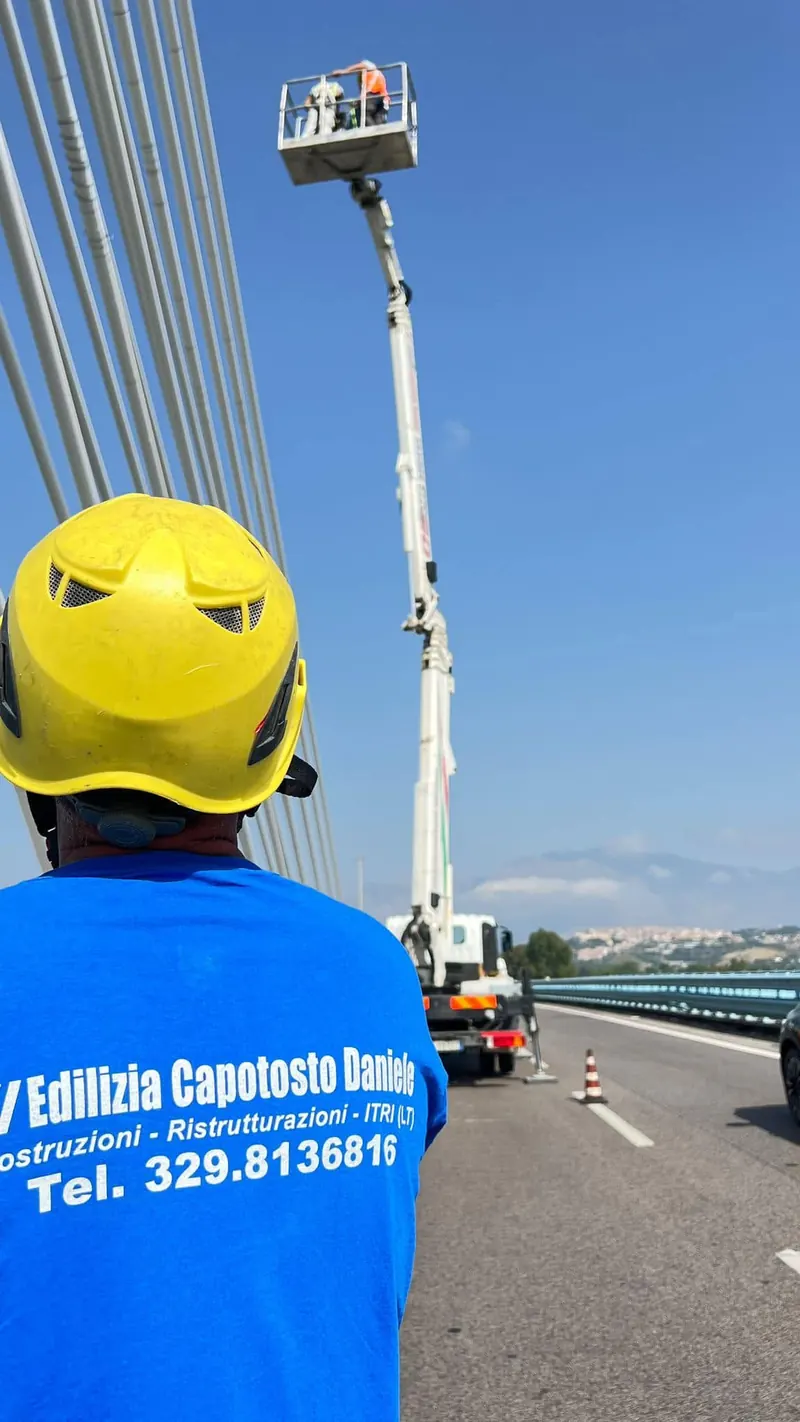 Operatore con la maglia aziendale che guida una piattaforma